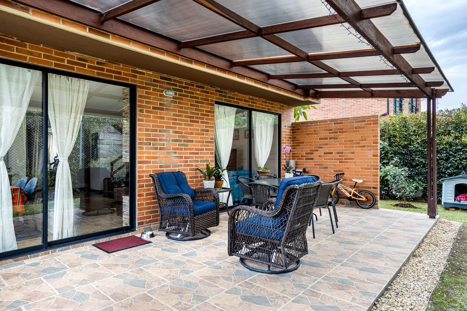 Attached patio cover over a paved seating area on a brick house
