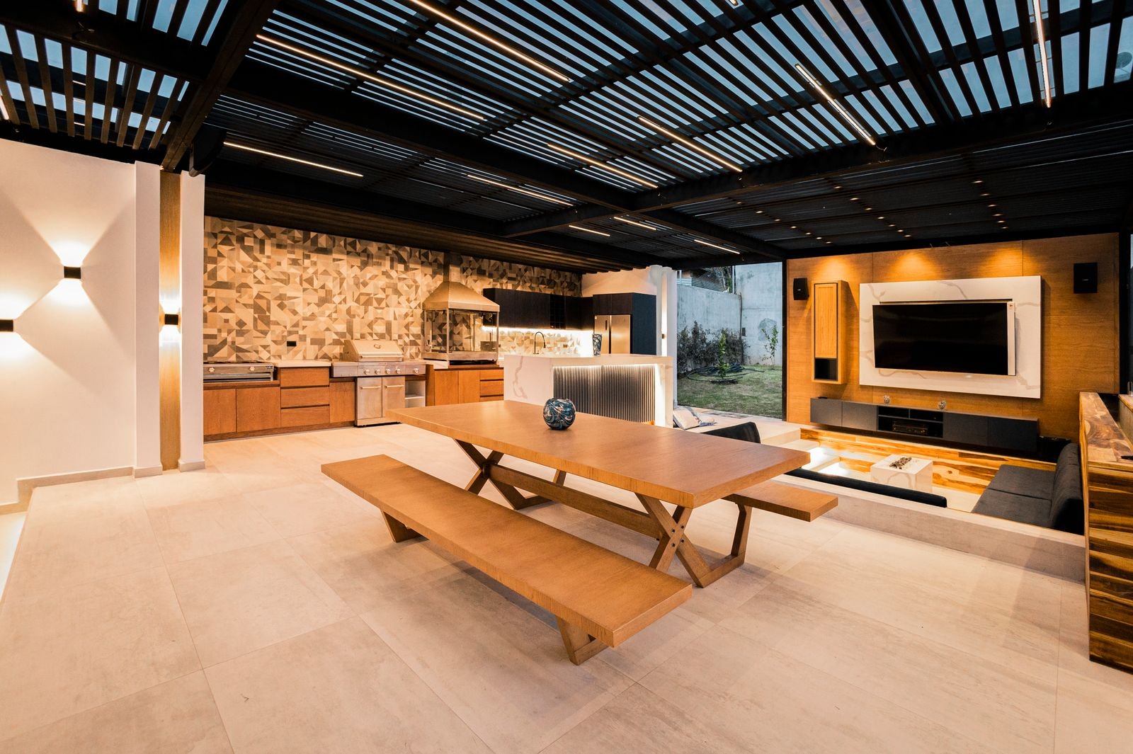 Outdoor kitchen and covered living area with stone and timber finishes